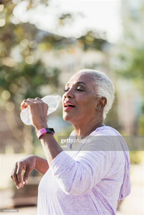 Senior Africanamerican Woman Drinking From Water Bottle High Res Stock