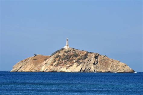 An Island With A Light House On It In The Middle Of The Ocean