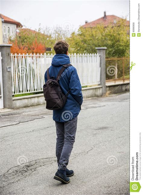 Teenage Boy Walking Alone In Street With Backpack Stock Photo Image