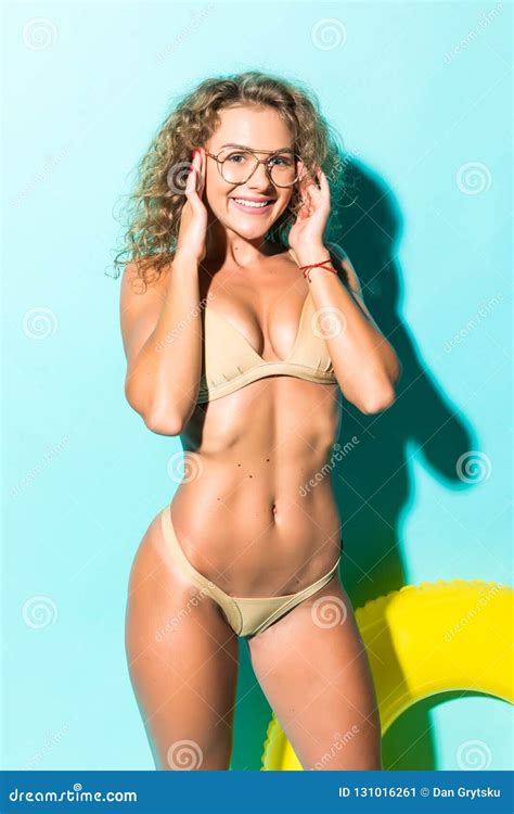 Portrait Of Beautiful Young Woman In Bikini And Glasses Playing With Inflatable Yellow Float