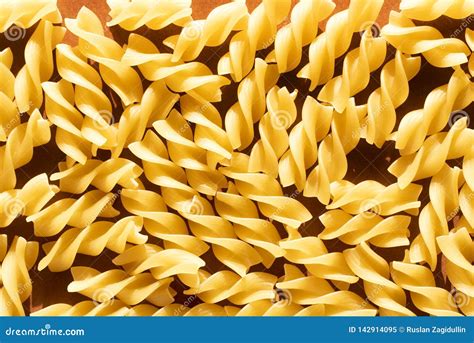 Macaroni In The Form Of Yellow Spirals On Brown Background Stock Image