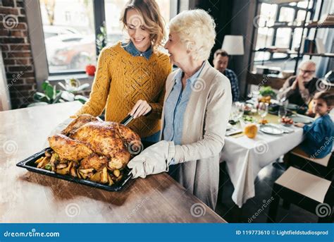 Smiling Senior Mother And Daughter With Thanksgiving Turkey Stock Photo