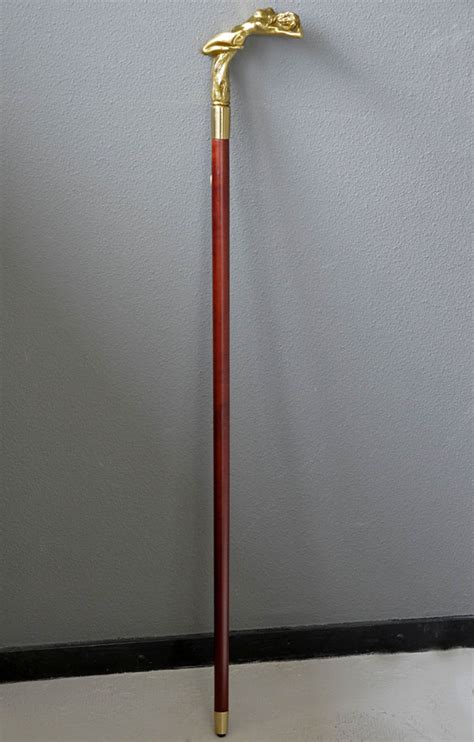 A Wooden Walking Stick With A Bronze Grip Of An Intense Female