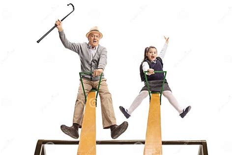 Cheerful Grandpa And His Granddaughter Having Fun On A Seesaw Stock