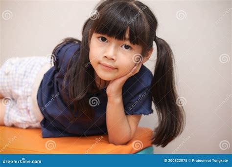 portrait of cute asian girl with black long hair lying on the bench