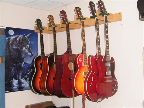 Use a wire hanging system. guitar hanger for wall - Google Search | Guitar hanger, Guitar, Band rooms