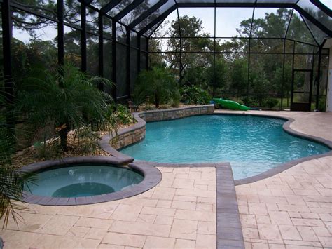 Screened In Pool With Spa Water Feature And Palm Trees In Garden Area