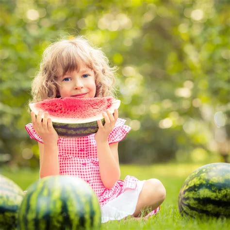 Little Girl Eating Watermelon In The Garden — Stock Photo © Famveldman
