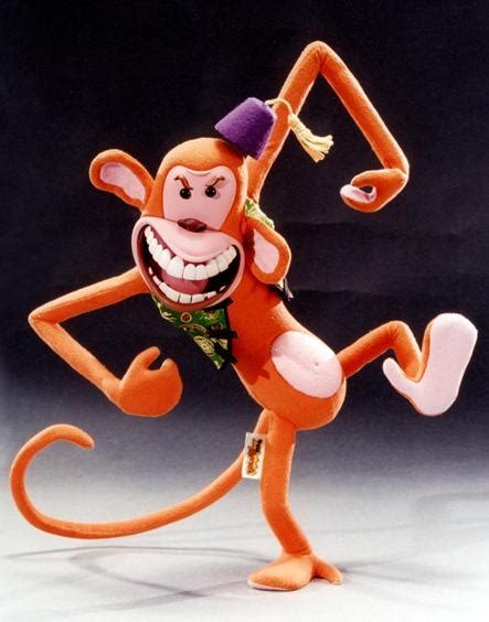 An Orange Monkey With A Hat On Its Head And Arms Is Dancing In The Air
