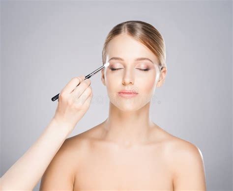 Attractive Young Woman Applying Powder On Her Cheeks Stock Photo