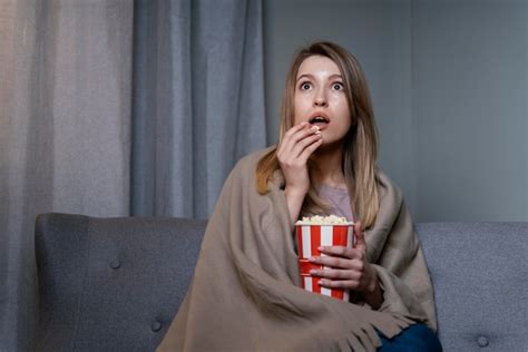 Free Photo Woman Watching Tv And Eating Popcorn