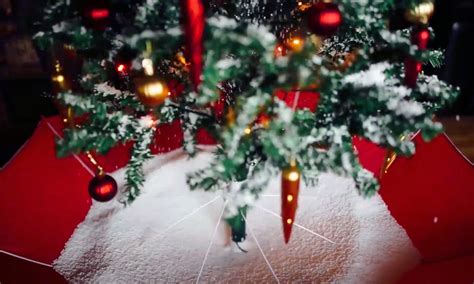Christmas lighted red and gold musical snowing tree round street lamp. Snowing Christmas Tree