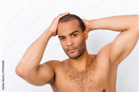 Confident Andsome Young Mulatto Nude Man Is Standing On The Pure White Background Fixing His