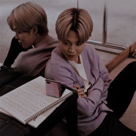 Two Young People Sitting Next To Each Other With Notebooks On Their Lap