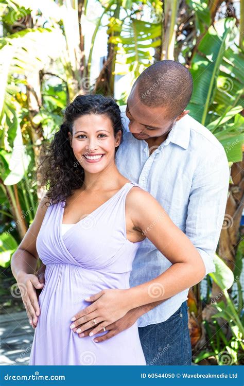 Portrait Of Happy Pregnant Wife With Husband Touching Belly Stock Photo