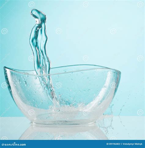 El Agua Que Salpica Al Bol De Vidrio En El Fondo Blanco Imagen De