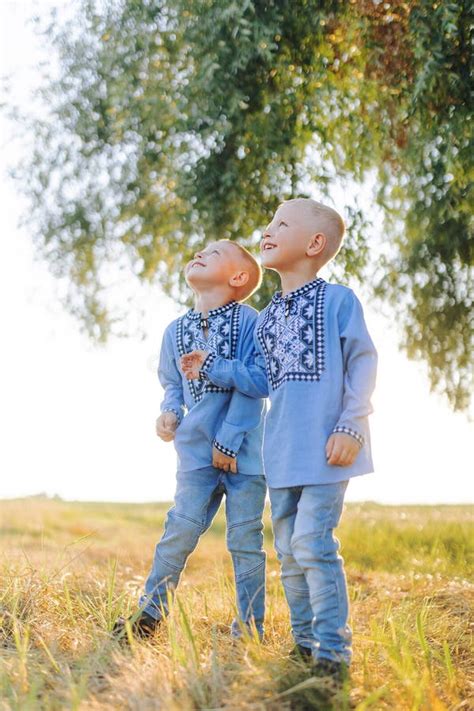 Happy Two Twins Brothers Have Fun And Play On Meadow Stock Image