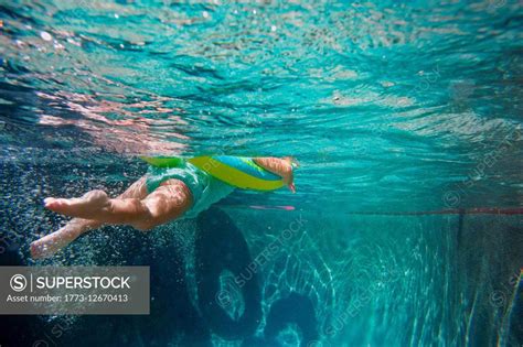 Underwater Shot Of Girl Kicking Legs In Swimming Pool Learning To Swim
