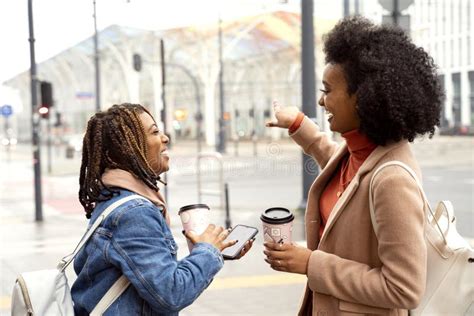 Two African Woman Friends Drinking Coffee Outdoor Smiling And Talking