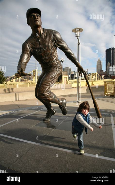 Boy In Front Of Roberto Clemente Statue Pretending To Hit A Home Run