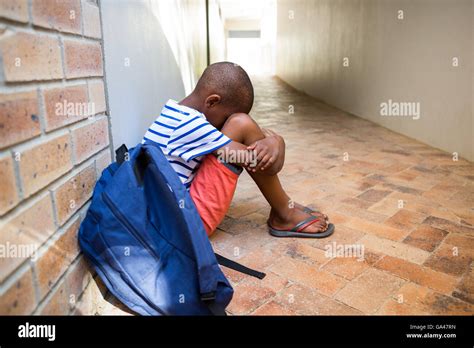 Boy Sitting Alone On School Corridor Stock Photo Alamy