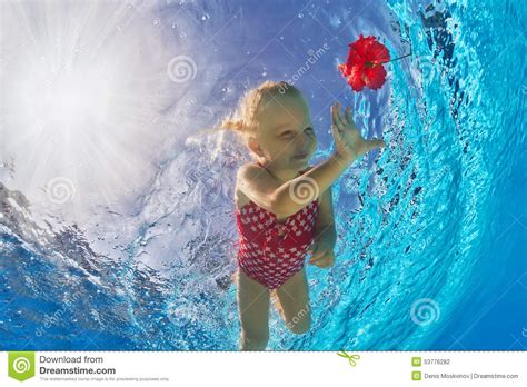 Muchacha Sonriente Que Nada Bajo El Agua En La Piscina Para La Flor Roja Tropical Foto De