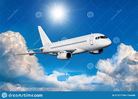 White Passenger Jetliner Fly In The Air Above Picturesque Clouds Stock