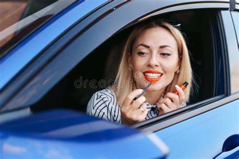 Woman Looking In Cars Side Mirror And Putting On Lipstick Stock Image