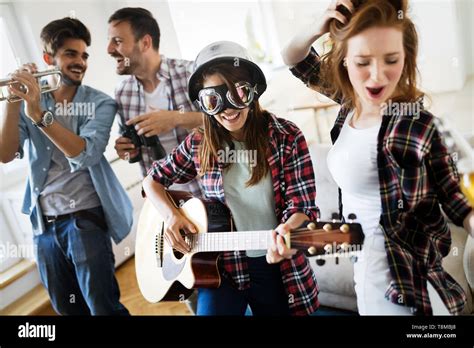 Cheerful Friends Having Party Together And Playing Instruments Stock