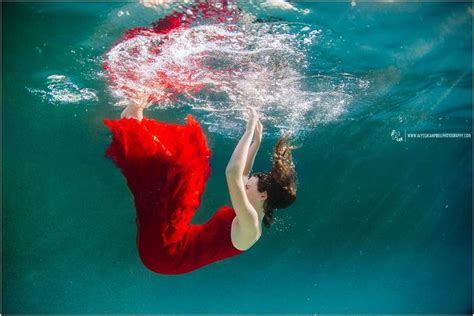 Brunette In Long Red Dress Falling Into Blue Green Water By Underwater