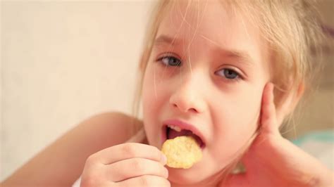 Young Girl Indoors Eating Chips Smiling Eating Harmful Food Stock