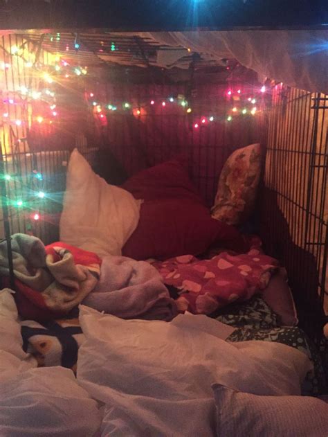 An Unmade Bed With Lots Of Pillows And Lights On The Headboard In