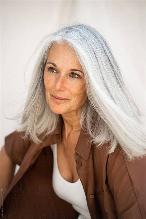 Fashion Portrait Of Beautiful Mature Woman In Front Of Sheet Backdrop Long White Hair Silver