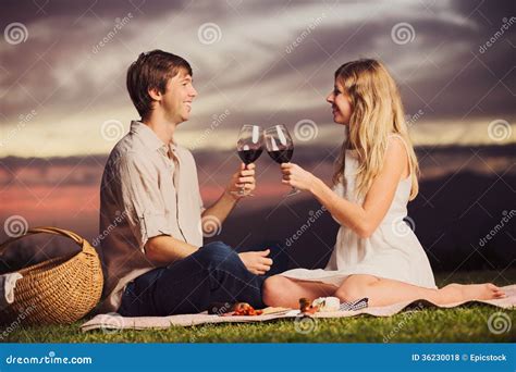 Couple Drinking Glass Of Wine On Romantic Sunset Picnic Stock Photo