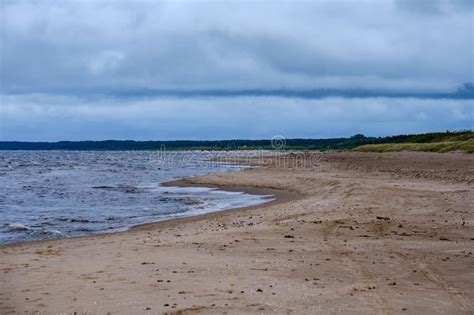 Dirty Beach By The Sea With Storm Clouds Above In Calm Evening Stock