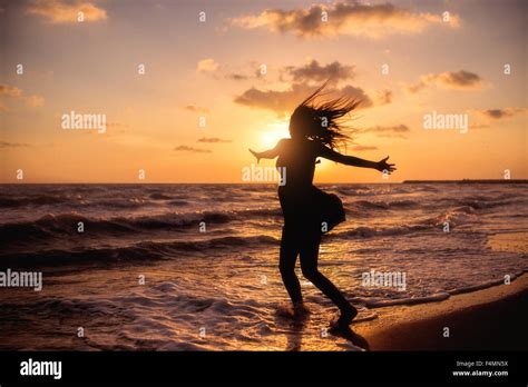 Happy Woman Jumping In Sea Sunset Stock Photo Alamy
