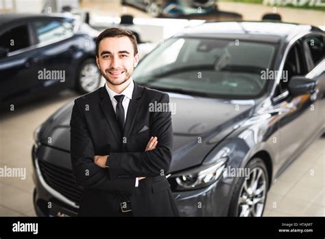 Handsome Young Classic Car Salesman Standing At The Dealership In Front