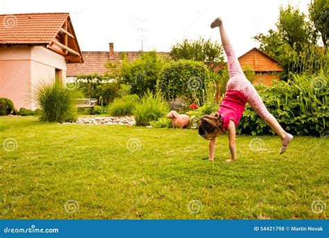 Child Doing Cartwheel In Backyard Stock Photo Image Of Gymnastics