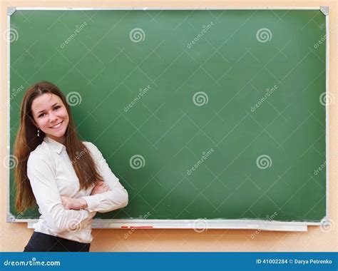 Student Girl Standing Near Blackboard In The Classroom Stock Photo