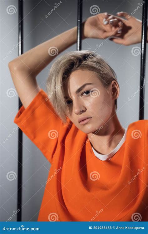 Cute Blonde On A Photo Shoot In The Prison Stays Behind Bars Stock