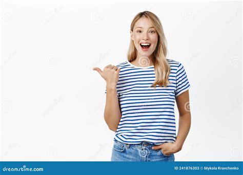 happy smiling blond woman pointing finger left showing announcement or banner announcing event
