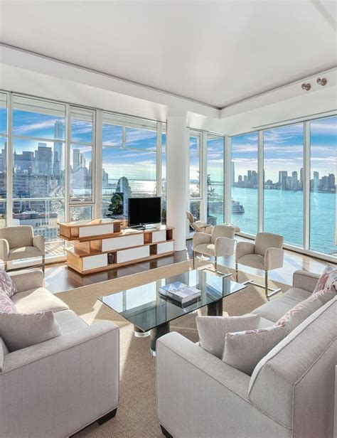 A Living Room Filled With White Furniture And Large Windows Overlooking