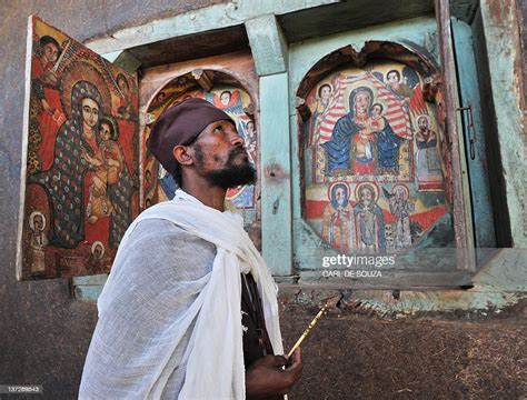 An Ethiopian Orthodox Christian Monk Looks Up While Holding A Cross