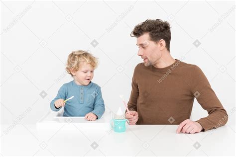 Foto De Padre Enseñando A Su Hijo A Usar Una Cuchara