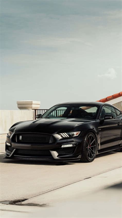 Download The Black Mustang Gt Is Parked On The Side Of The Road