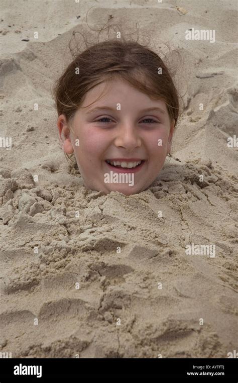 Young Girl Buried In Sand Stock Photo Alamy