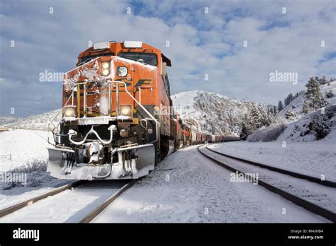 A Bnsf Train Coming Down The Tracks In The Snow On A Cold Bright