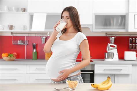 Beautiful Pregnant Woman Drinking Milk In Kitchen Womens Healthcare