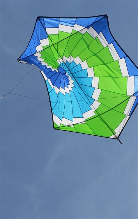 A Blue And Green Kite Flying In The Sky