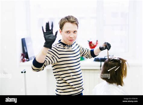 the hairdresser in the beauty salon makes hair coloring. young male